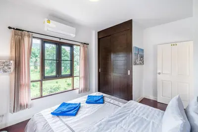 a bedroom with a large bed with blue pillows on it at Sea eagle pool villa in Ao Nang Beach