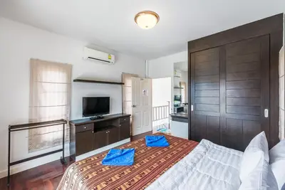 a bedroom with a large bed and a television at Sea eagle pool villa in Ao Nang Beach