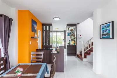 a dining room and kitchen with orange walls at Sea eagle pool villa in Ao Nang Beach
