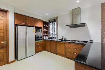 a kitchen with wooden cabinets and a stainless steel refrigerator at Villa Palavee (B2) in Ao Nang Beach