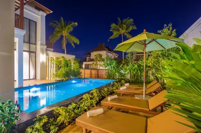 a swimming pool with chairs and an umbrella at Villa Palavee (B2) in Ao Nang Beach