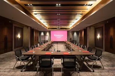 a large conference room with a long table and a pink screen at Ramada Plaza by Wyndham Chao Fah Phuket in Phuket Town