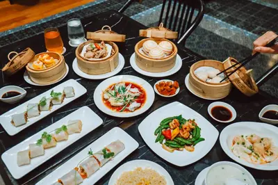 a table full of plates of food on a table at Ramada Plaza by Wyndham Chao Fah Phuket in Phuket Town