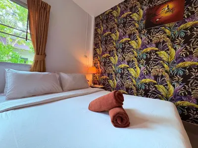 a towel sitting on a bed in a bedroom at Canal Resort in Nai Yang Beach