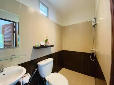 a bathroom with a white toilet and a sink at Canal Resort in Nai Yang Beach