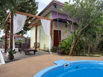 a house with a swimming pool in front of a house at Canal Resort in Nai Yang Beach