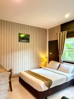a bedroom with a large bed and a window at Canal Resort in Nai Yang Beach