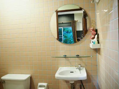 a bathroom with a sink and a mirror and a toilet at Canal Resort in Nai Yang Beach