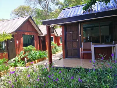 a small house with a porch and a garden at Phi Phi Long Beach Bungalow ( Had Yao) in Phi Phi Don