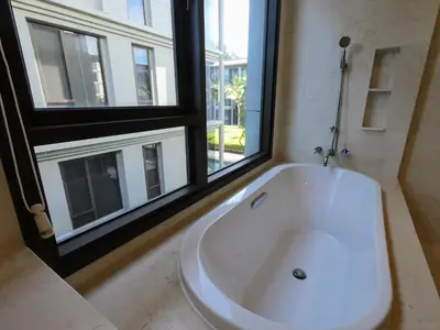 a large white bath tub in a bathroom with a window at Baan Mai Khao condo in Mai Khao Beach