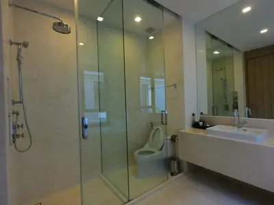 a bathroom with a shower and a toilet and a sink at Baan Mai Khao condo in Mai Khao Beach