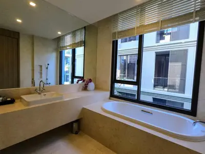 a large bathroom with a tub and a large window at Baan Mai Khao condo in Mai Khao Beach