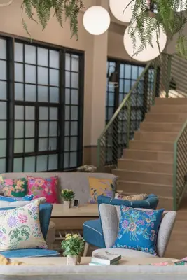 a living room with couches and a staircase at The Blanket Hotel Phuket Old Town in Phuket Town