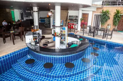 a large blue pool with a bar in the middle at Wazza's Patong Apartment, Smart TV and Fast Wi-Fi in Patong Beach