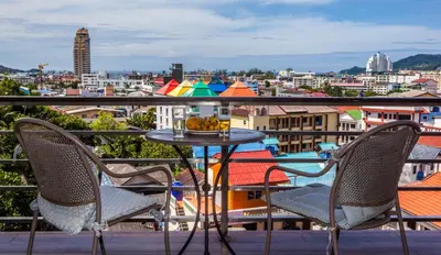 a table and chairs on a balcony with a view of a city at Wazza's Patong Apartment, Smart TV and Fast Wi-Fi in Patong Beach