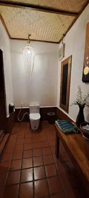 a bathroom with a toilet and a table and a chandelier at Viking Nature Resort in Phi Phi Don