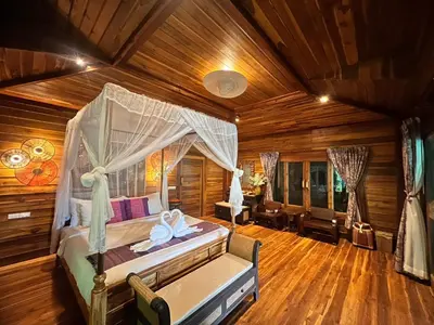 a bedroom with a bed in a room with wooden floors at Viking Nature Resort in Phi Phi Don