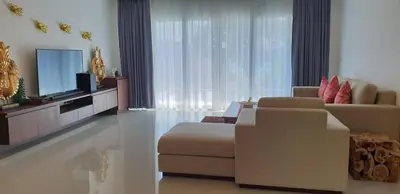 a living room with a couch and a television at JJ Queen Villa and Spa Kohyaonoi in Ko Yao Noi