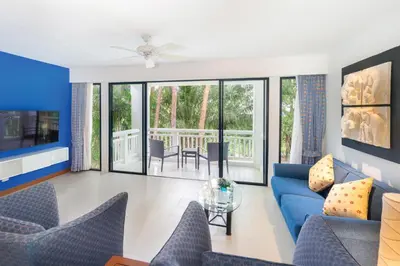 a living room with a blue couch and chairs at Homm Suites Laguna, part of Banyan Group in Bang Tao Beach