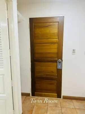 a wooden door in a room with a tile floor at Surin Bay Inn in Surin Beach