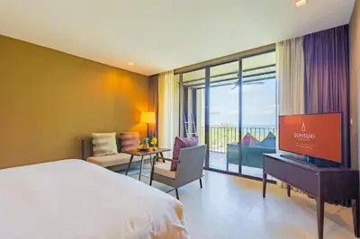 a hotel room with a bed and a flat screen tv at SUNSURI PHUKET, Nai Harn Beach in Nai Harn Beach