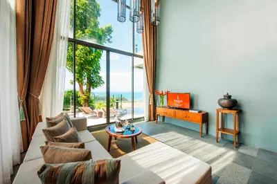 a living room with a couch and a table at SUNSURI PHUKET, Nai Harn Beach in Nai Harn Beach