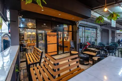 a restaurant with wooden benches in front of a counter at The Z Nite Hostel in Phuket Town