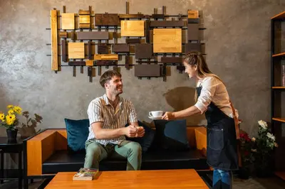 a woman giving a man a cup of coffee in a room at The Z Nite Hostel in Phuket Town