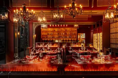 a restaurant with a bar with tables and chandeliers at Katathani Phuket Beach Resort - SHA Extra Plus in Kata Beach