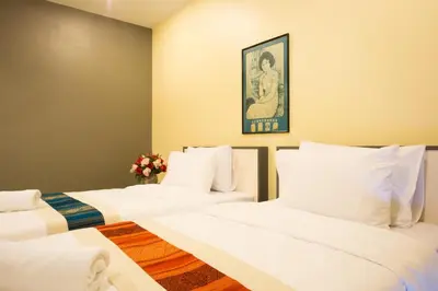 two beds in a room with white sheets at Central Residences in Phuket Town