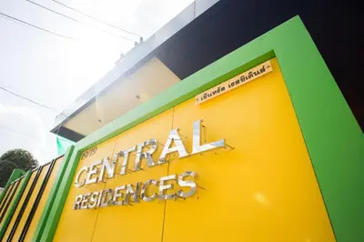 a yellow and green building with a sign on it at Central Residences in Phuket Town