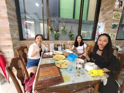 a group of women sitting at a table in a restaurant at Baan Ketkeaw Guest House 2 in Patong Beach