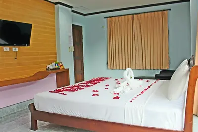 a bedroom with a white bed with red flowers on it at Baan Ketkeaw Guest House 2 in Patong Beach