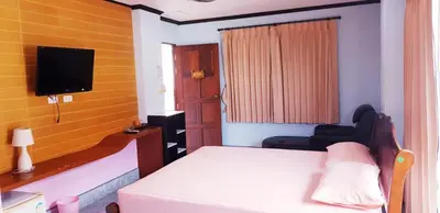 a small room with a bed and a television at Baan Ketkeaw Guest House 2 in Patong Beach