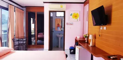 a bedroom with a bed and a tv on a wall at Baan Ketkeaw Guest House 2 in Patong Beach