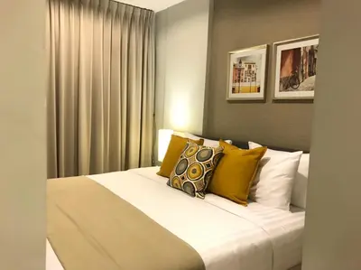 a bedroom with a large white bed with yellow pillows at Zcape at Bangtao in Bang Tao Beach