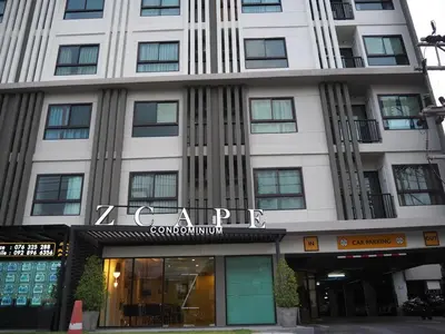 a large white building with a sign on it at Zcape at Bangtao in Bang Tao Beach