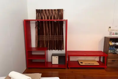 a red book shelf with a box in a room at Phuket Old Town Hostel in Phuket Town