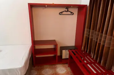 a small room with a bed and a red bench at Phuket Old Town Hostel in Phuket Town