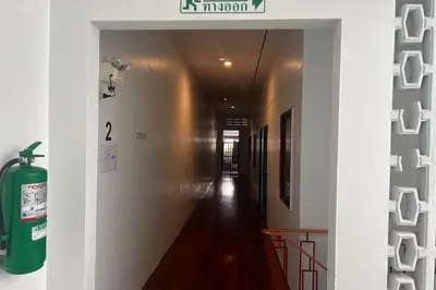 a hallway with a green fire extinguisher on the wall at Phuket Old Town Hostel in Phuket Town