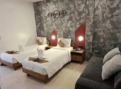 a hotel room with two beds and a couch at U Sabai Living Hotel in Patong Beach
