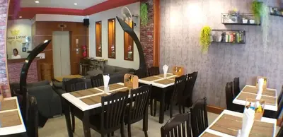 a dining room with tables and chairs in a restaurant at U Sabai Living Hotel in Patong Beach