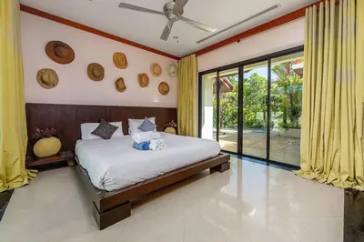 a bedroom with a bed and a large window at VILLA TOBA Pool Baan Bua Estate Naiharn beach in Nai Harn Beach
