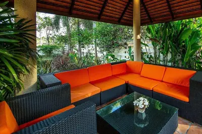 an orange couch on a patio with a table at VILLA TOBA Pool Baan Bua Estate Naiharn beach in Nai Harn Beach