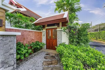 a house with a wooden door and some plants at VILLA TOBA Pool Baan Bua Estate Naiharn beach in Nai Harn Beach