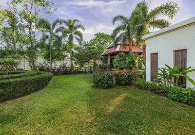 a yard with a white house and palm trees at VILLA TOBA Pool Baan Bua Estate Naiharn beach in Nai Harn Beach