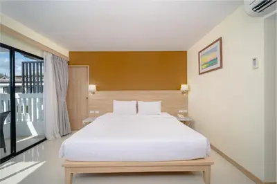 a bedroom with a white bed and a large window at Aonang Buri Resort in Ao Nang Beach