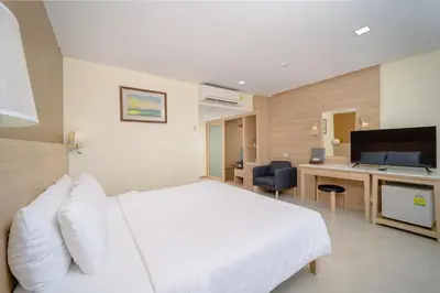 a hotel room with a white bed and a desk at Aonang Buri Resort in Ao Nang Beach