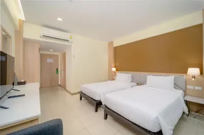 a hotel room with two beds and a desk at Aonang Buri Resort in Ao Nang Beach