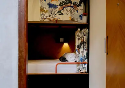 a small bed in a room with a curtain at TAN Hostel x Cafe , Aonang Beach in Ao Nang Beach